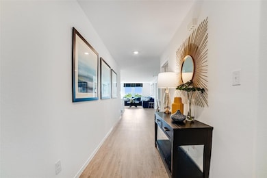 Hall with light wood finished floors and recessed
