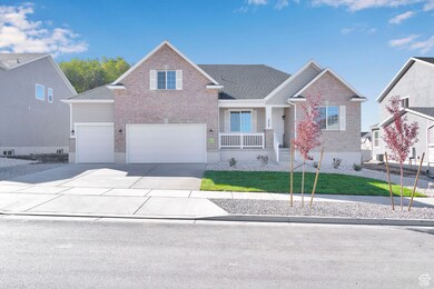 View of front of property with covered porch, brick siding, concrete driveway, a front yard, and a garage