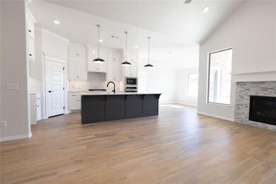 Kitchen with decorative light fixtures, white cabi