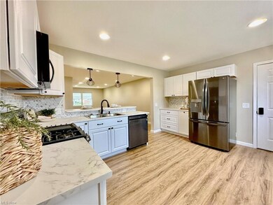 Kitchen with light countertops, white cabinetry, a