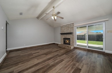 Unfurnished living room featuring dark wood-type flooring, a fireplace, a ceiling fan, and a textured ceiling