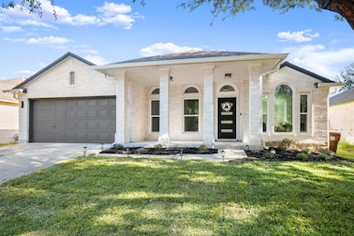 View of front of home with a porch, concrete driveway, a front lawn, an attached garage, and brick siding