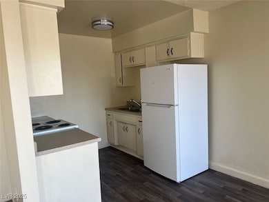 Kitchen featuring white appliances, a sink, dark w