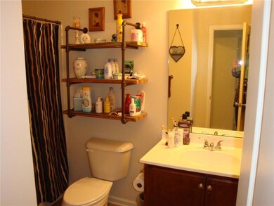 Bathroom featuring walk in shower, vanity, and toi