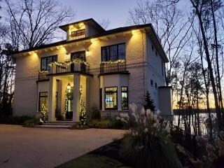 View of front of property with a balcony, concrete driveway, and brick siding