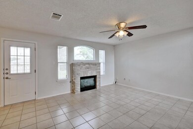 Unfurnished living room featuring light tile patterned floors, a fireplace, a textured ceiling, and ceiling fan