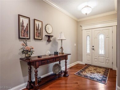 Entrance foyer featuring ornamental molding and dark wood-style flooring