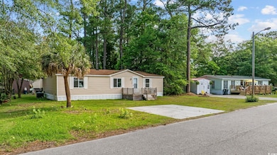 Manufactured / mobile home featuring a front lawn and a wooden deck