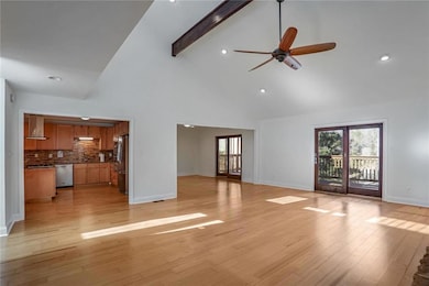 Unfurnished living room featuring beamed ceiling, ceiling fan, high vaulted ceiling, and light hardwood / wood-style flooring