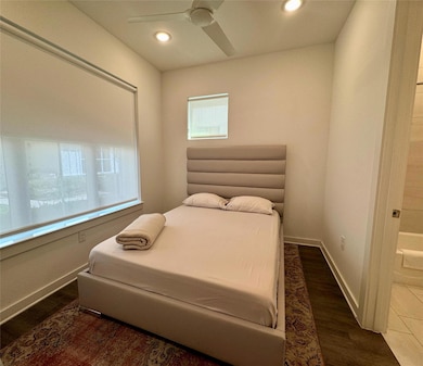 Bedroom featuring wood finished floors, recessed 