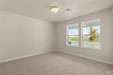Spare room with light colored carpet and a textured ceiling