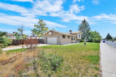 Tri-level home with driveway, brick siding, and an attached garage