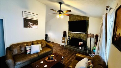 Living area featuring a textured ceiling, a firepl