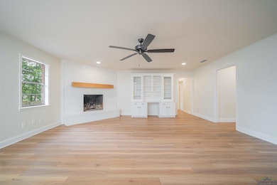 Unfurnished living room featuring a fireplace, light wood-style flooring, recessed lighting, and a ceiling fan