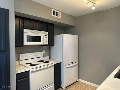 Kitchen featuring white appliances, light stone co
