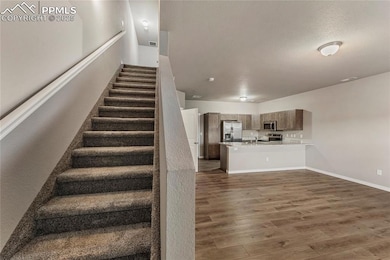 Stairway with baseboards and wood finished floors