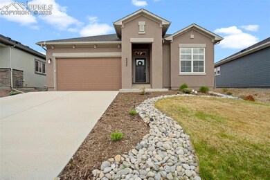 View of front of property featuring stucco siding, driveway, an attached garage, and a front yard