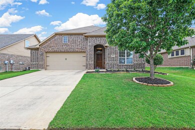 View of front of property featuring a garage and a front lawn