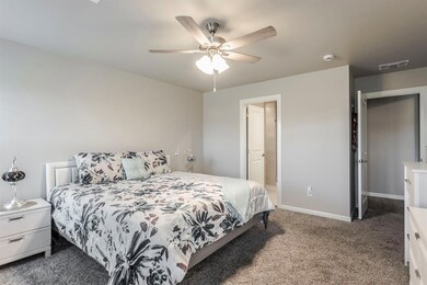 Carpeted primary bedroom featuring ceiling fan