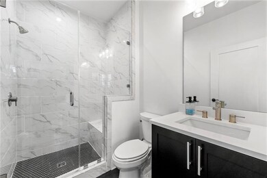 Full bath with toilet, vanity, and a shower stall