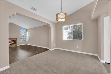 Unfurnished living room featuring vaulted ceiling,