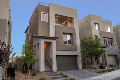 Contemporary house with an attached garage, stucco siding, driveway, and a balcony