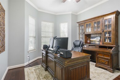 The office area has wood floors, a beautiful bay window looking out to the front of the home, crown molding, and a ceiling fan.  It is the perfect work space, but it is a flexible and could work as a guest space, play room etc.  The half bath is directly across from the office.
