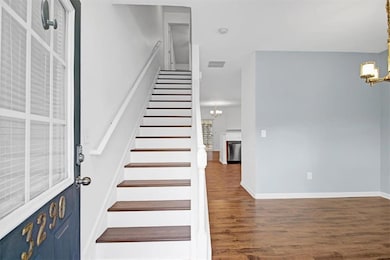 Staircase featuring an inviting chandelier, wood f