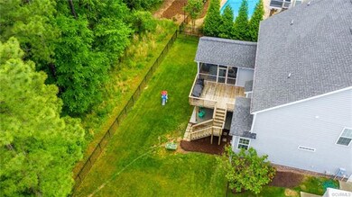 Aerial view of he fenced back yard, screen porch, deck and patio.  Note the wooded area that is a natural buffer that will never be disturbed!