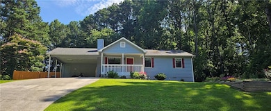 Single story home featuring driveway, a porch, an attached carport, and a chimney