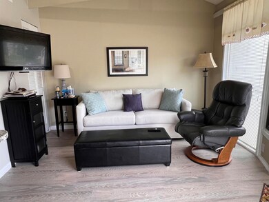 Living room featuring light wood-style flooring and baseboards