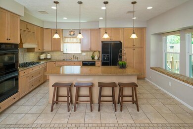 Entertaining a crowd won’t ever be a problem in this kitchen, offering a 5 burner gas cooktop, double ovens, an expansive window with window seat, and a large granite top island with stylish pendant lights above provides additional seating for four.