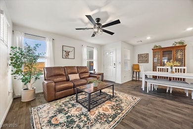 Spacious living area with fan and lots of windows for natural light.