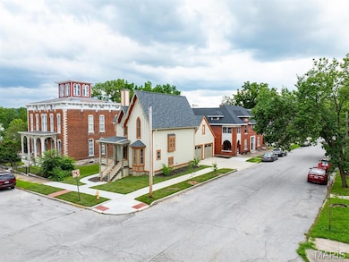 View of front of house featuring a shingled roof and driveway