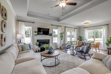 Living room with ceiling fan, crown molding, a rai