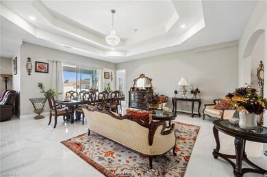 Living room featuring a tray ceiling, marble finis