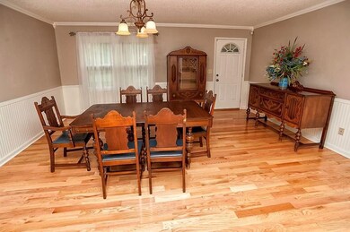 Contains crown moulding, hardwood floors, and bead board wainscoting.