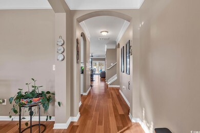Corridor with wood-type flooring and ornamental molding