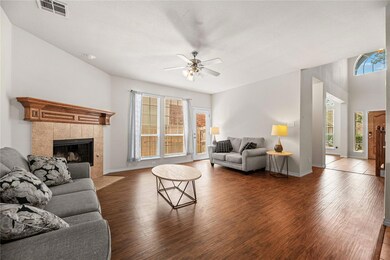 Living room with ceiling fan, a tiled fireplace, a