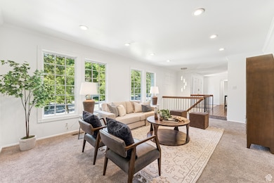 Living area featuring crown molding, light carpet, and recessed lighting