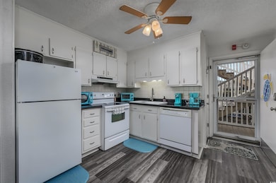 Kitchen with white cabinetry, white appliances, da