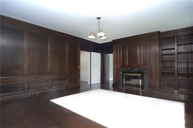 Family room with detailed custom paneling & bookca