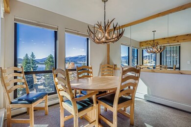 Dining room with a mountain view, carpet, a chandelier, and beamed ceiling