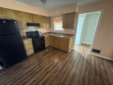 Kitchen featuring visible vents, dark wood finishe