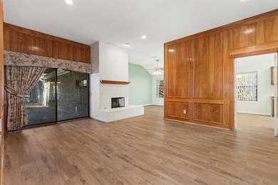 The warm, formal living room features rich wood paneling that evokes the charm of a classic library or study—an inviting space ideal for relaxing or entertaining guests.