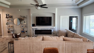 Living room featuring ceiling fan, ornamental mold
