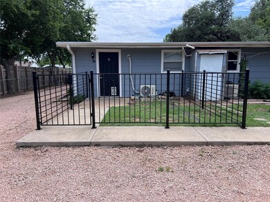 Single story home with a gate and a fenced front 