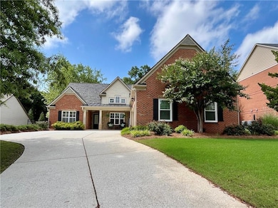 View of front of house with brick siding, driveway, a front yard, and a standing seam roof