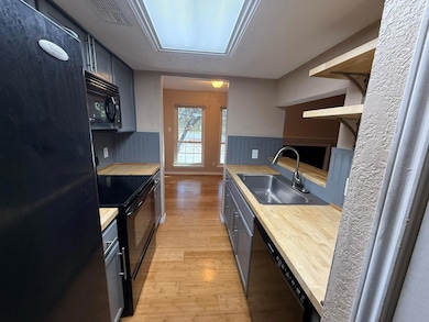 Kitchen with sink, black appliances, and light har