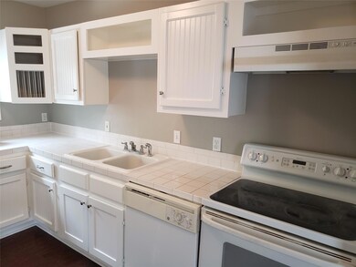 Kitchen with white cabinets, white appliances, sin